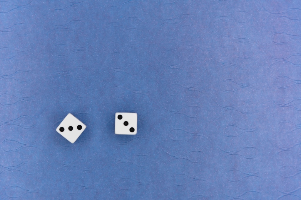 white and black dice on blue textile